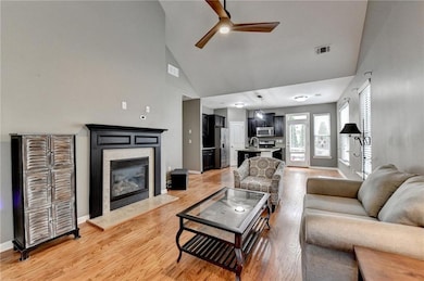 Living room featuring a ceiling fan, a glass cover