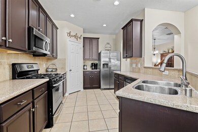 Alternate view of the kitchen with dual sided SS sink and breakfast bar.