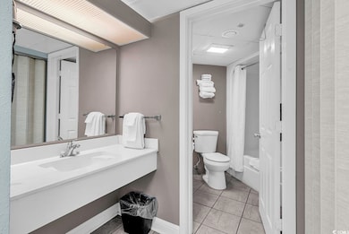 Bathroom with light tile patterned flooring, vanity, and shower / tub combo with curtain