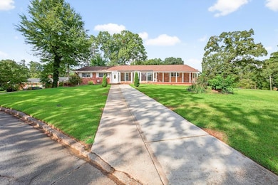 Ranch-style home featuring a front lawn and brick siding