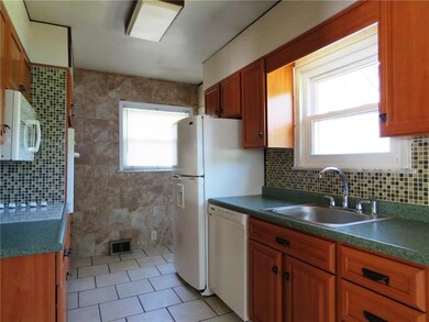 Renovated kitchen with new tile floor, tile back s