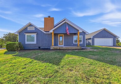 View of front facade with covered porch, a front lawn, and a chimney