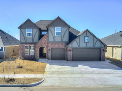 Tudor home featuring stucco siding, concrete driveway, and brick siding
