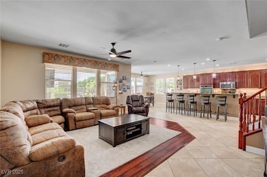 Living area with a ceiling fan with light, tile fl