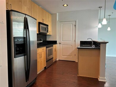 Kitchen featuring appliances with stainless steel finishes, a sink, dark countertops, dark wood-style flooring, and recessed lighting