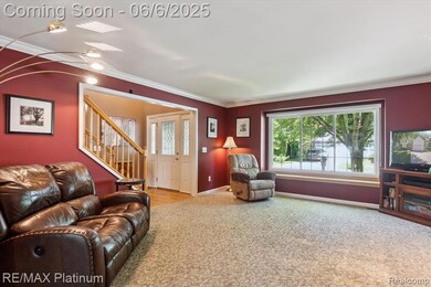 Sunlight pours through the picture window, brightening this cozy living space with classic charm.