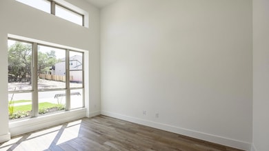 Empty room with dark wood-type flooring and baseb