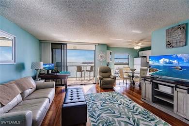 Living room with ceiling fan, a textured ceiling,