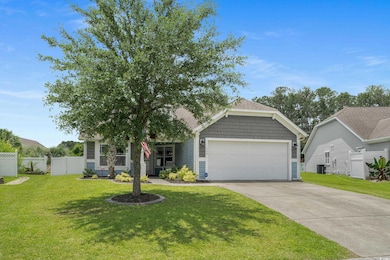 View of property hidden behind natural elements with driveway and a garage