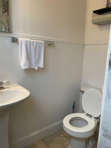 Bathroom featuring tile walls and toilet