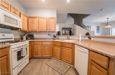 Kitchen with white appliances, light wood-style fl