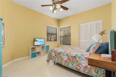 Tiled bedroom with ceiling fan and a closet