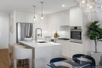 Kitchen featuring modern cabinets, appliances with stainless steel finishes, light wood-style flooring, white cabinets, and recessed lighting