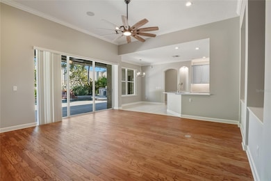 Family Room with crown molding, updated ceiling fan, hardwood floors, in ceiling speakers and views of the pool