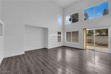 Unfurnished living room with a towering ceiling and wood finished floors