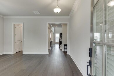 Entrance foyer with dark wood-type flooring and crown molding