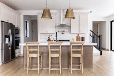 Kitchen featuring stainless steel appliances, pendant lighting, a kitchen island, and white cabinets