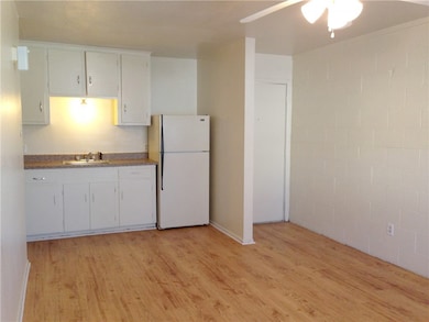 Kitchen with freestanding refrigerator, a sink, li