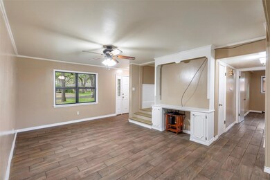 Unfurnished living room featuring crown molding, hardwood / wood-style floors, and ceiling fan