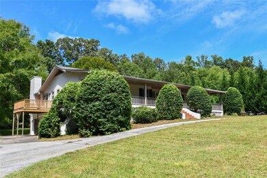 View of front facade with a front yard and a wooden deck