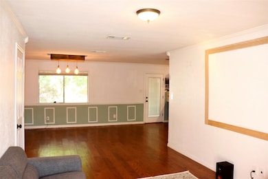 Unfurnished room with crown molding, dark wood-sty