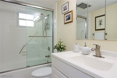 Full bath featuring combined bath / shower with glass door, vanity, and a textured ceiling
