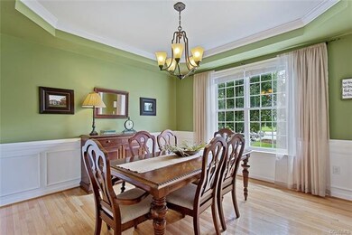 Dining Room with tray ceiling, chandelier, crown a