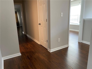 Hallway with dark wood-style floors and baseboards