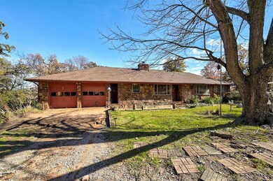 Ranch-style house featuring a front yard and a gar