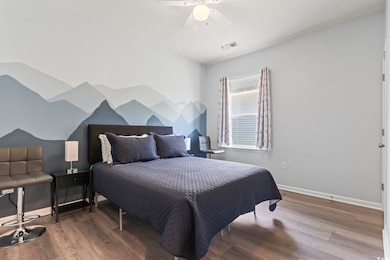 Bedroom featuring wood finished floors and a ceiling fan