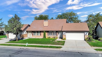 View of front of property with a front yard, an attached garage, brick siding, concrete driveway, and roof with shingles