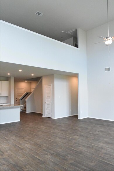 Unfurnished living room featuring a high ceiling,