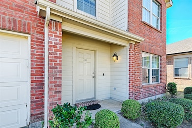 Doorway to property featuring brick siding and a garage