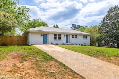 Ranch-style house with fence, a front lawn, brick 