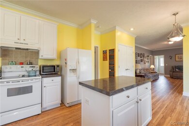 Kitchen with white cabinets, white appliances, lig