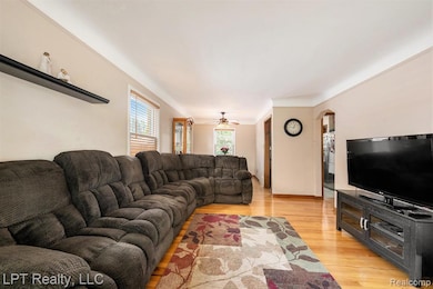 Living room with light wood finished floors and ceiling fan