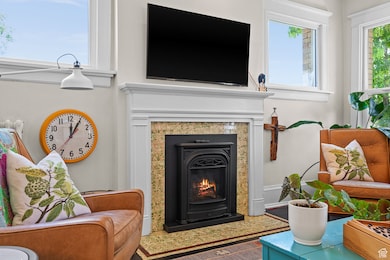 Living area with a warm lit fireplace and wood finished floors