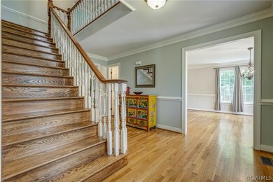 Stairs with a notable chandelier, light wood-type
