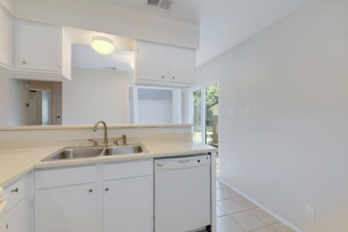 Kitchen with dishwasher, a sink, light tile patte