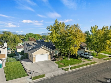 View of front of house featuring driveway, a garage, roof with shingles, a gate, and brick siding