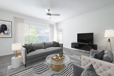 Living room with a textured ceiling, baseboards, a