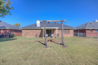 Back of house featuring brick siding, a patio, and a chimney