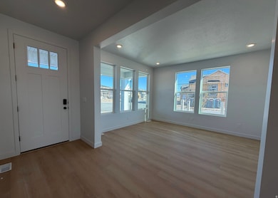 Foyer entrance with light wood finished floors, recessed lighting, and a textured ceiling