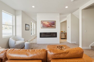 Living room with a large fireplace, recessed lighting, light carpet, and a textured ceiling