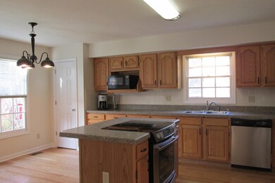 Kitchen with hardwood floors, eat-in area, pantry, and stainless appliances.