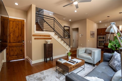 Living room with stairs, ceiling fan, hardwood / wood-style floors, and recessed lighting