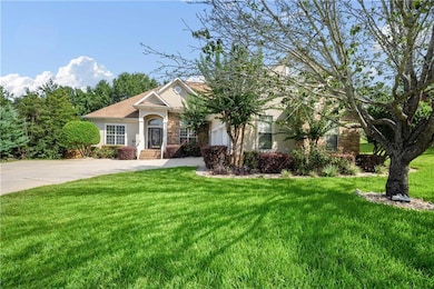 View of front of property featuring stucco siding, a front yard, and stone siding
