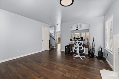 Office with a textured ceiling, dark wood finished floors, and a ceiling fan