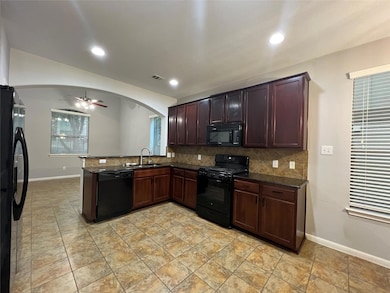 Kitchen featuring black appliances, ceiling fan, 
