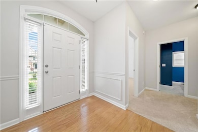 Foyer entrance featuring healthy amount of natural light, light wood finished floors, and baseboards